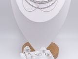 a white display case with a necklace and bracelets on it