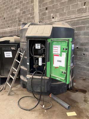 un tas d'ordures à côté d'un immeuble avec une échelle
