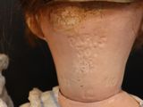 a close up of a doll with a hat on