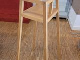 a wooden chair sitting in a room next to a red chair