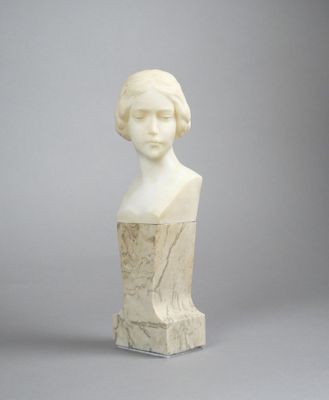 sculpture d'une tête de femme sur une base en marbre