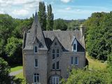 une vue aérienne d'un grand bâtiment en pierre entouré d'arbres