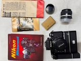 un appareil photo, un livre, un objectif et d'autres objets disposés sur une table