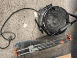 un petit ventilateur posé par terre à côté d'un morceau de bois
