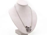 necklace on a mannequin display with a flower in the middle