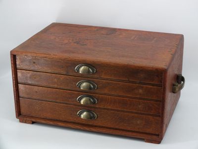 a small wooden box with five drawers on it