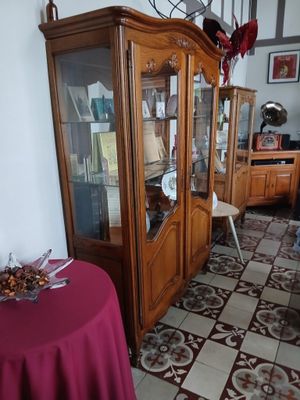une table recouverte d'une nappe rouge et un meuble avec une porte vitrée