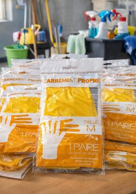 several bags of cleaning supplies sitting on top of a wooden table