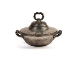 an antique silver plate with a lid and handles on a white background
