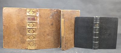 two old books are sitting next to each other on a table