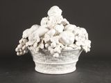 un vase blanc rempli de crânes et de fleurs posé sur une table