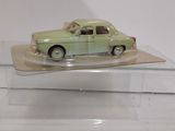 a green toy car on display in a glass case