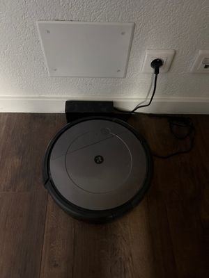 une photo d'un robot aspirateur posé sur le sol, près d'un mur