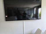 two white chairs in a room with a flat screen tv on the wall