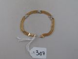 bracelet à chaîne plaqué or avec un fermoir et une étiquette de prix
