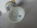a white vase with a blue and yellow design on it