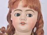 a close up of a doll with long red hair