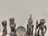 un groupe de figurines en bois assises les unes à côté des autres sur une table