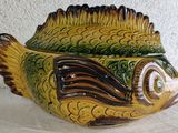 a yellow and green fish shaped container on a table