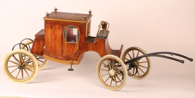 a small wooden horse drawn carriage on a white surface