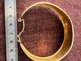 une image représentant un bracelet en or entouré d'une chaîne