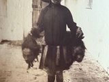 an old photo of a woman holding a bunch of chickens