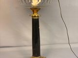 a black and gold table lamp with a black shade on top of it