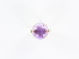 une bague en or jaune sertie d'une pierre violette