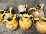 cinq vases marron posés les uns à côté des autres sur une table