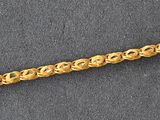 a close up of a gold chain on a gray surface