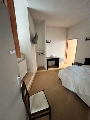 une chambre avec un lit et une chaise