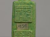 a small green bottle with writing on it on a table