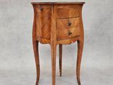 une petite table en bois avec deux tiroirs d'un côté et un tiroir de l'autre côté