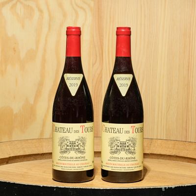 two bottles of wine sitting on top of a barrel