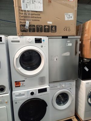 une pile de machines à laver et un sèche-linge dans un entrepôt