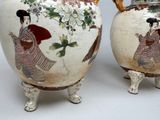 two vases with asian designs on them on a table