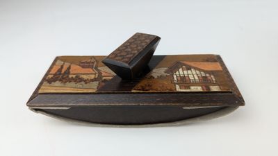 a small wooden box with a lid on a white surface