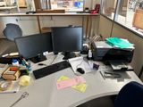 un bureau sur lequel se trouvent deux écrans d'ordinateur et une imprimante