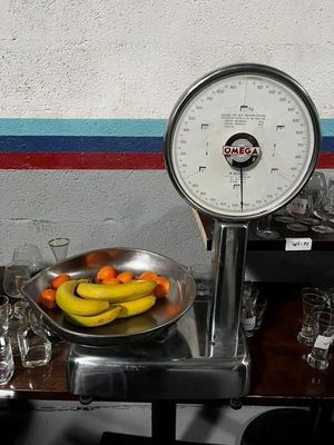 a bowl of fruit on a table with a scale