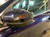 a reflection of a car with a caution sticker on the side mirror