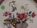 a plate with a bird and flowers on it on a table