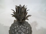 un ananas en métal posé sur une surface blanche