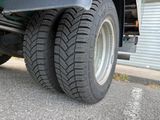 a truck that has a tire on the side of the road