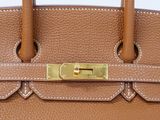 an image of a brown leather handbag with a gold lock
