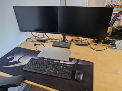 un bureau d'ordinateur équipé de deux écrans, d'un clavier et d'une souris