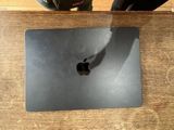 un ordinateur portable MacBook Pro d'Apple posé sur une table en bois