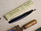 a razor, a razor blade, and a box of wax on a table