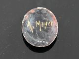 a close up of a small metal object with writing on it