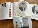 three open books on a wooden table with pictures of men and women