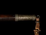 a close up of a knife with a wooden handle on a black background